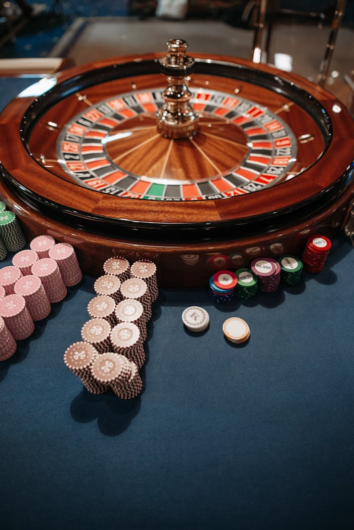 about-01 Roulette wheel on table with neatly stacked poker chips, capturing the essence of a casino.